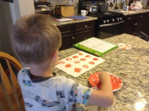 Kona says the short vowel sound before stamping a "pumpkin" on the letter.