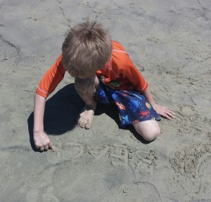 Kona practiced some spelling words in the sand.